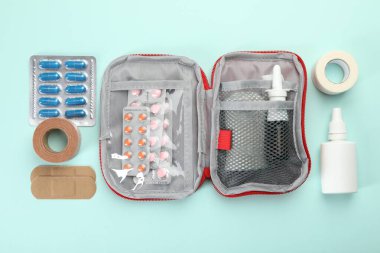 First aid kit. Different medical supplies on light blue background, flat lay