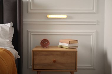 Kapalı bir odada beyaz duvarda parıldayan modern LED lamba.