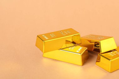 Açık mercan zemin üzerinde parlak altın külçeler, yakın plan. Metin için boşluk