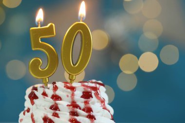 50. yaş günü. Kek üzerindeki mumların yanma sayısı bulanık arka planda ışıklar, yakın plan ve metin için boşluk. Bokeh etkisi
