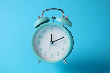 Açık mavi arkaplanda turkuaz alarm saati