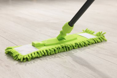 Tahta zeminde mikrofiber paspas, yakın plan. Temizlik ekipmanı