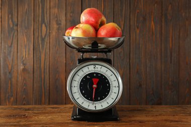 Retro mechanical kitchen scale with apples on wooden table