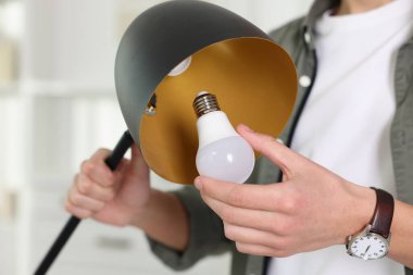 Evdeki ampulü değiştiren adam, yakın plan.