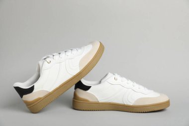 Açık gri arka planda şık bir çift spor ayakkabı. Sıradan ayakkabılar.