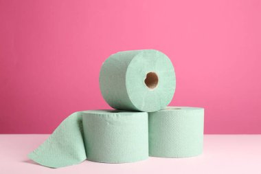 Pembe arka planda yeşil tuvalet kağıdı ruloları