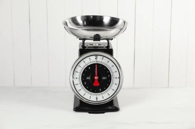 Mutfak terazisi ve beyaz mermer masa.