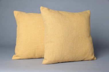 Gri arkaplanda iki yumuşak dekoratif yastık