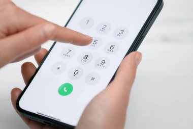 Akıllı telefondan arka plandaki bulanık numaraya çeviren kadın, yakın plan