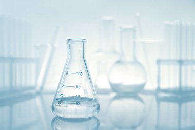 Ayna yüzeyinde ışık arkaplanına karşı sıvı olan şişe