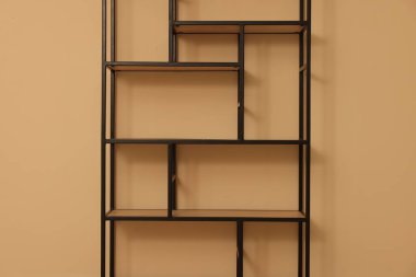 Empty shelving unit near beige wall indoors, closeup