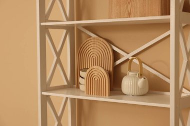 Shelving unit with decor near beige wall indoors, closeup