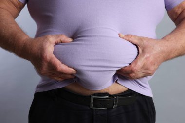Gri arka planda dar tişörtlü şişman adam, yakın plan.