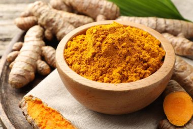 Tabakta zerdeçal tozu, masada kökler, yakın plan.