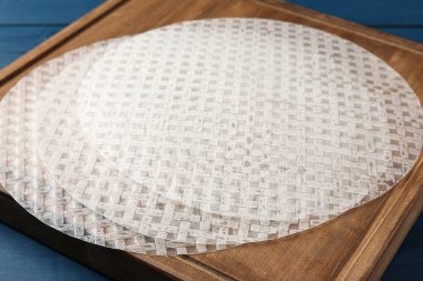 Mavi ahşap masadaki yenilebilir pirinç kağıtları, yakın plan.