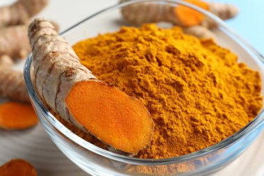 Kasede Aromatik zerdeçal tozu ve masada taze kökler, yakın plan.