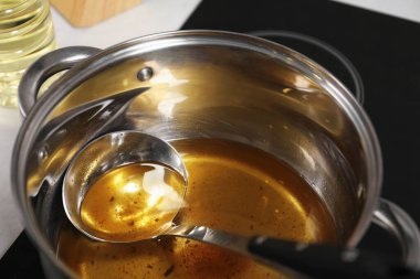 Sobadaki tencerede kullanılan yağ ve kepçe, yakın plan.