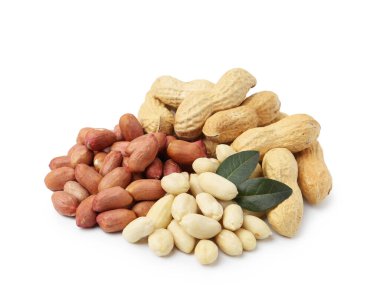 Farklı fıstık yığınları ve beyaz yapraklar.