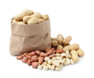 Kese kağıdındaki kabuksuz fıstıklar ve soyulmuş olanlar beyaz üzerinde.