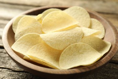 Tahta masada kasede patates cipsi, yakın plan.