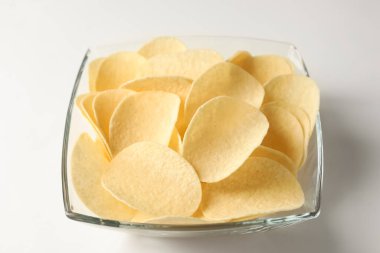 Beyaz arka planda lezzetli patates cipsi, yakın plan.