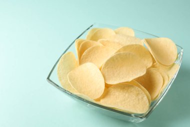 Açık mavi arka planda leziz patates cipsleri, yakın plan. Metin için boşluk