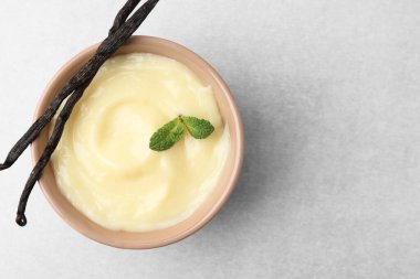 Lezzetli vanilyalı puding, nane ve kapsüller açık gri masa, üst manzara. Metin için boşluk