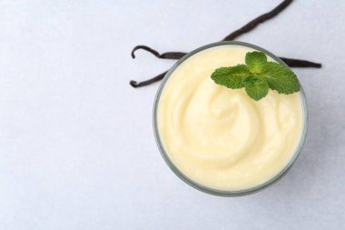 Lezzetli vanilyalı puding, nane ve kapsüller açık gri masa, üst manzara. Metin için boşluk