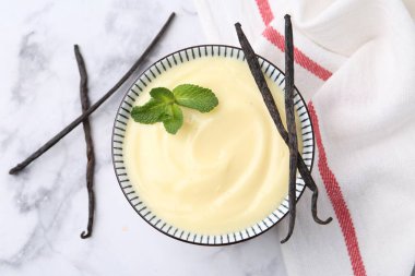 Lezzetli vanilyalı puding, nane ve kapsüller beyaz mermer masada, düz yerde