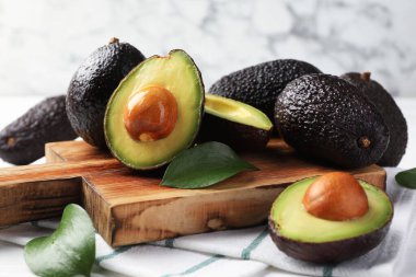 Avokadoların tamamı beyaz masada, yakın plan.