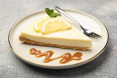 Gri desenli masada naneli ve karamel soslu lezzetli limonlu cheesecake.