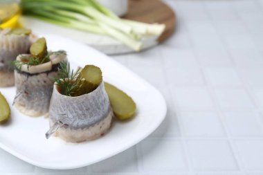 Turşulu ve dereotlu lezzetli ringa dürümleri açık fayanslı masada, yakın plan. Metin için boşluk