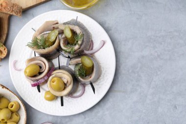 Gri desenli masada zeytinli, turşulu, dereotlu ve soğanlı lezzetli ringa dürümleri. Metin için boşluk