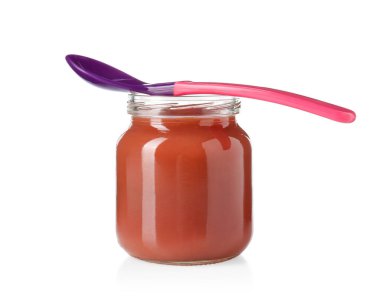Bebek maması. Cam kavanozda lezzetli püre ve beyaza izole edilmiş kaşık.