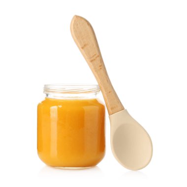 Bebek maması. Cam kavanozda lezzetli püre ve beyaza izole edilmiş kaşık.