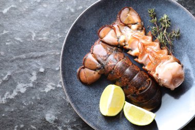 Çiğ ıstakoz kuyruğu, kireç ve kekik karanlık masa, üst manzara. Metin için boşluk