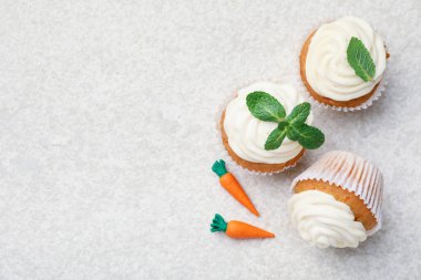Hafif desenli masa üzerinde naneli havuçlu kekler, düz yatak. Metin için boşluk