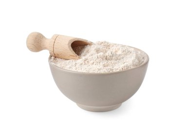 Kahverengi pirinç unu ve kepçeyle beyaz kasede izole edilmiş.