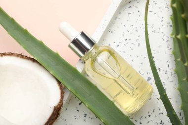 Saç tedavisi. Kozmetik ürün, hindistan cevizi ve aloe yaprakları bej arka planda, düz yatar