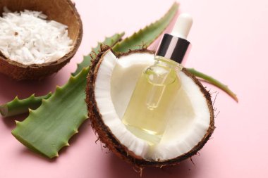 Saç tedavisi. Kozmetik ürün, hindistan cevizi, tereyağı ve aloe yaprakları pembe arka planda, yakın plan