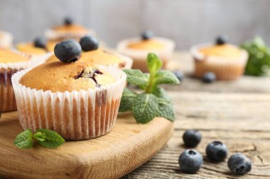 Yaban mersinli lezzetli kekler ve ahşap masada nane şekeri, yakın plan.