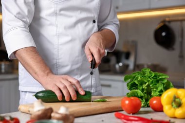 Mutfakta kabak kesen profesyonel aşçı, yakın plan.