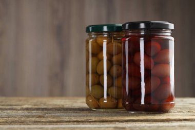 Ahşap masada cam kavanozlarda zeytin turşusu. Metin için boşluk