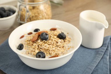 Sütlü yulaf ezmesi, yaban mersini ve badem tabakta, yakın plan.