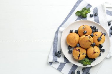 Yaban mersinli lezzetli kekler ve beyaz ahşap masa üzerinde nane şekeri, üst manzara. Metin için boşluk