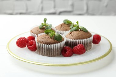 Beyaz masada ahududu ve nane şekerli lezzetli kekler, yakın plan.