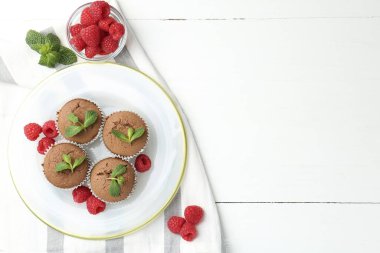 Beyaz ahşap masada ahududu ve nane şekerli nefis çörekler. Metin için boşluk