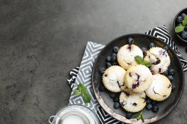 Yaban mersinli lezzetli çörekler, pudra şekeri ve siyah desenli masada nane şekeri, düz yatak. Metin için boşluk