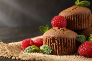 Ahududu ve nane aromalı lezzetli çörekler karanlık masada, yakın plan.