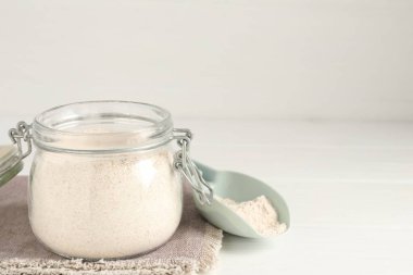 Kahverengi pirinç unu beyaz ahşap masada. Metin için boşluk